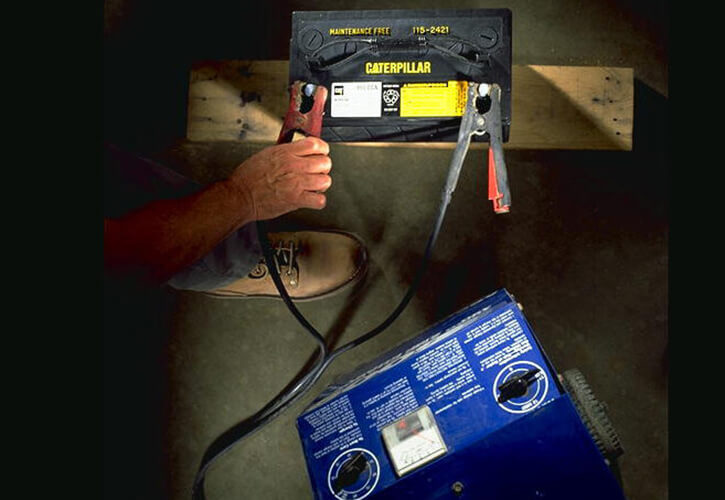 Man jump starting a Cat battery